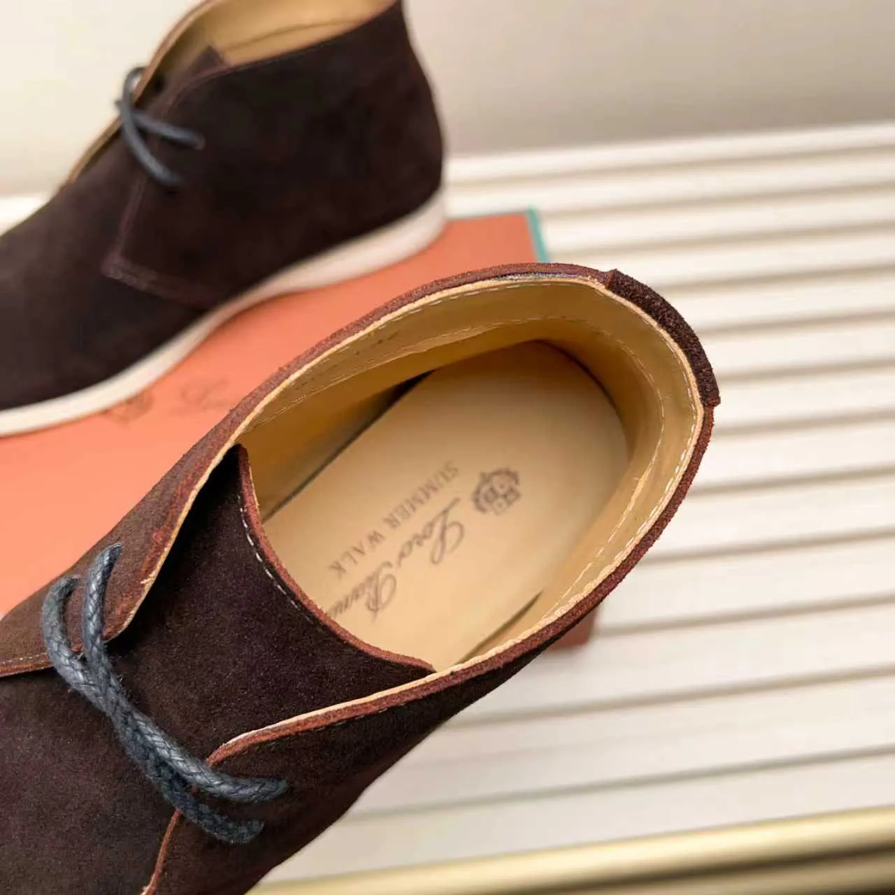 Men's Shoes 💰420 Loro Piana reimagines the desert boot—a modern, comfortable interpretation of a classic 1940s style. Crafted from suede calfskin, it exudes elegance. The tight texture of suede calfskin is not only durable but also looks casual and sophisticated. Add a timeless piece to your shoe collection, harmoniously blending comfort, style and Loro Piana's heritage of craftsmanship. Acetate satin detail on the inside White sole with LP lettering for added traction Space for a personalized signature on the heel Tonal suede trim Upper: 100% cow split suede Sole: 100% Rubber lining: Cow leather
